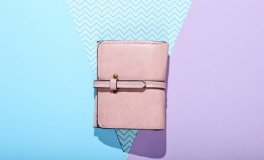 Pastel arka planda pembe deri cüzdan. Üst görünüm