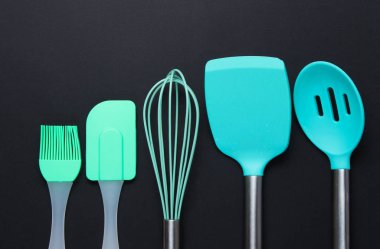 Siyah arka planda silikon mutfak aletleri. Üst görünüm.
