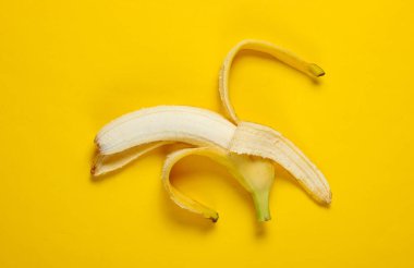 Minimalizm meyve konsepti. Sarı arka planda olgunlaşmış muz. Üst görünüm
