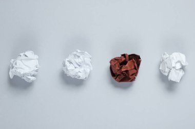 Eşsizlik kavramı, ırk ayrımcılığı. Gri arka planda beyaz ve kahverengi kağıt toplar. Üst görünüm, minimalizm işi