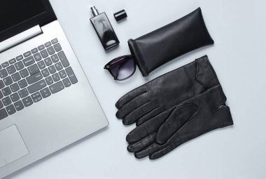 Modern laptop, gri arka planda kadın aksesuarları. Üst görünüm