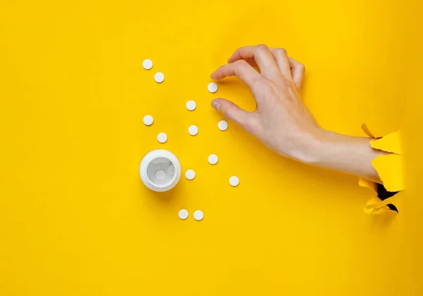 Kvinnlig Hand Tar Piller Genom Sönderrivet Gult Papper Minimalistisk Kreativ — Stockfoto