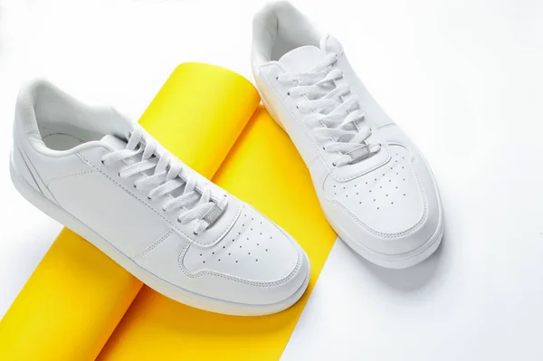 Zapatillas Blancas Sobre Rollo Enrollado Papel Amarillo Sobre Fondo Blanco —  Fotos de Stock