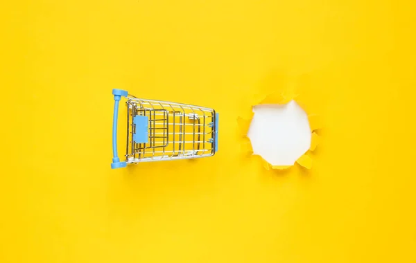 Mini Alışveriş Arabası Sarı Kağıtta Yırtık Bir Delik Asgari Alışveriş — Stok fotoğraf