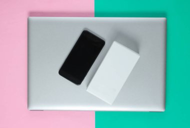 Boksu açma, tekno blog yazma kavramı. Yeni bir akıllı telefon kutusu, pastel arka planda dizüstü bilgisayar..