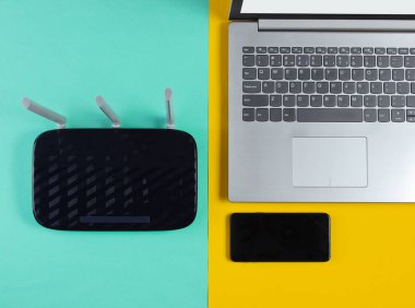 Wi-fi yönlendirici, akıllı telefon, renkli arka planda dizüstü bilgisayar. Modern aletler. Üst görünüm