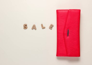 Bej bir arka planda kırmızı moda cüzdan ve kelime indirimi. Üst Manzara. Asgari konsept