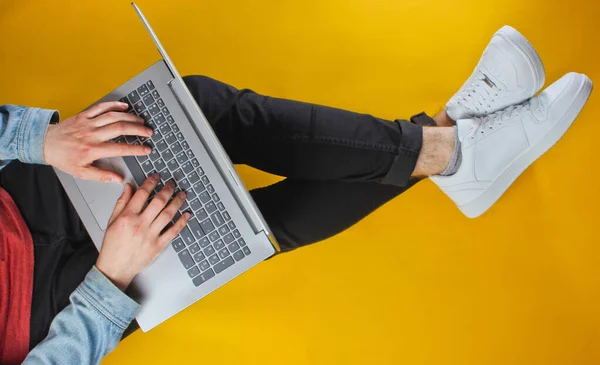 在线工作者的概念 希斯特先生在笔记本电脑上打字 坐在黄色的背景上 工作室拍摄 顶部视图 — 图库照片