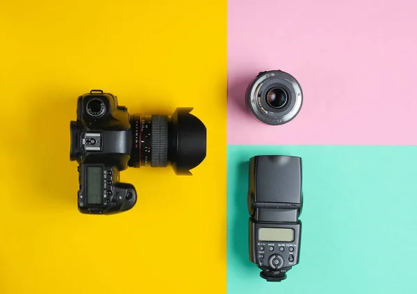 Camera, flash, lens on colored pastel background. Equipment photographer. Top view. Minimalism