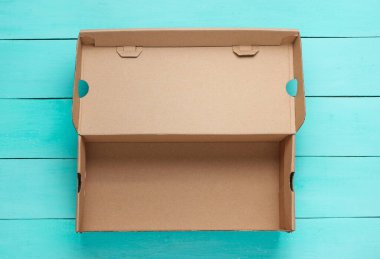 Mavi ahşap arka planda boş karton kutu. Üst görünüm