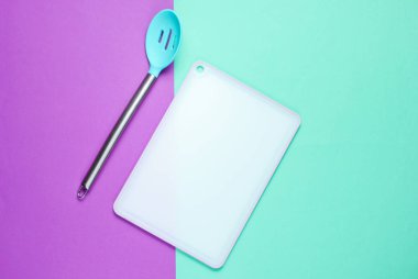 kitchen board with kitchen spoon on colored background. Asian cuisine