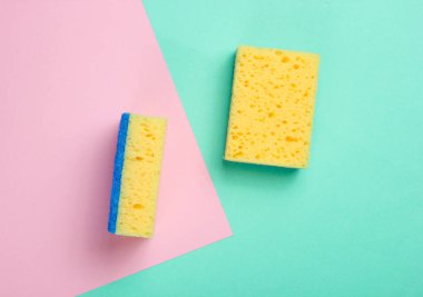 Minimalizm konseptini temizlemek. Pastel arka planda süngerler. Üst görünüm