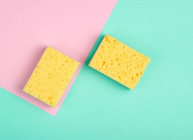 Minimalizm konseptini temizlemek. Pastel arka planda süngerler. Üst görünüm