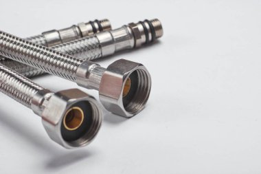 Beyaz arka planda iki metal boru hortumu.