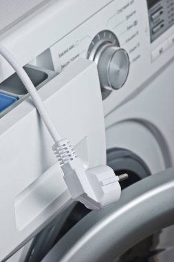 Elektrik prizi ile yakın plan çamaşır makinesi parçası.