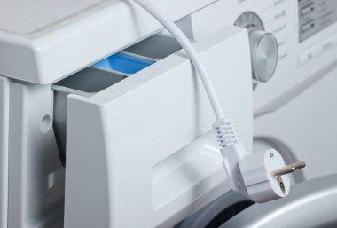 Elektrik prizi ile yakın plan çamaşır makinesi parçası.