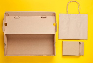 Eko konsepti. Karton kutular, sarı arka planda kağıt torba. Üst görünüm