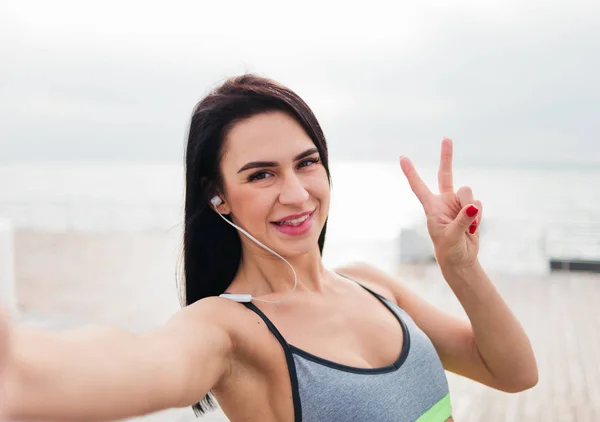 Mulher Morena Alegre Sportswear Fazendo Selfie Mostrando Símbolo Ervilhas Praia — Fotografia de Stock