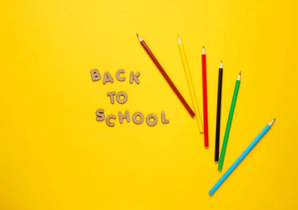 学校时间概念 黄色背景上的彩色铅笔 带着课本返回学校 顶部视图 — 图库照片