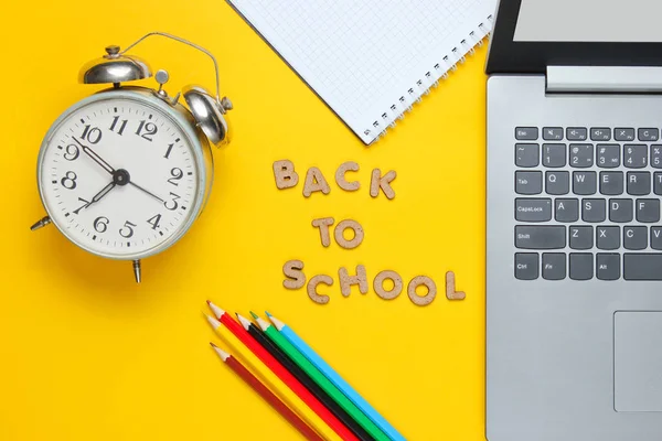 Skoltid Minimalistiskt Koncept Laptop Färgpennor Anteckningsbok Väckarklocka Gul Bakgrund Slogan — Stockfoto