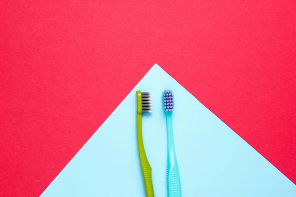 Dos Cepillos Dientes Nuevos Sobre Fondo Papel Rojo Azul Concepto — Foto de Stock