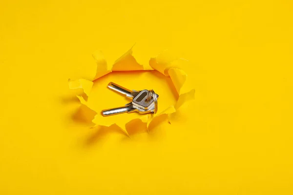 Schlüsselbund Aus Metall Durch Ein Zerrissenes Loch Auf Gelbem Papier — Stockfoto