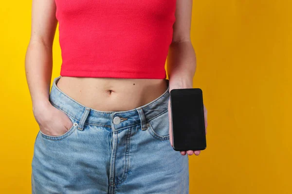 Mujer Joven Sostiene Mano Teléfono Inteligente Sobre Fondo Amarillo Cortar —  Fotos de Stock