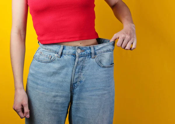 Weight Loss Concept Woman Trying Large Blue Jeans Yellow Background — 스톡 사진