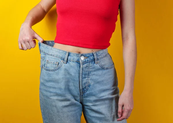 Weight Loss Concept Woman Trying Large Blue Jeans Yellow Background — Stock Photo, Image