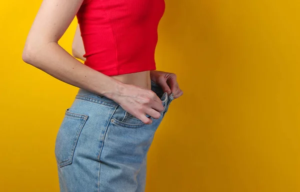 Weight Loss Concept Woman Trying Large Blue Jeans Yellow Background — 스톡 사진