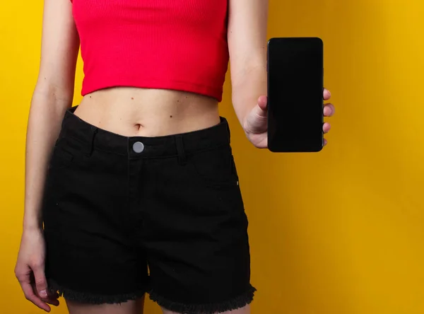 Young Woman Holds Her Hand Smartphone Yellow Background Crop Photo — Stock Photo, Image