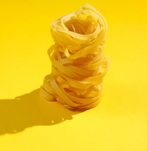 在黄色背景上抹上生干的意大利面 最低限度食物概念 — 图库照片