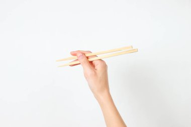 Beyaz arka planda kadın yemek çubukları var. Minimalist gıda konsepti. Üst görünüm