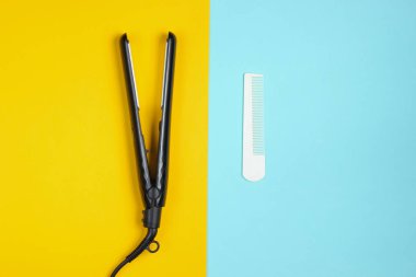 Minimalist güzellik ve moda hala hayat. Mavi sarı arka planda tarak ve saç düzleştirici. Üst manzara, düz uzanma