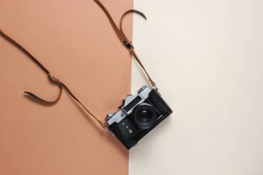 Kahverengi arka planda kayışı olan deri kapaklı antika film kamerası. Üst görünüm