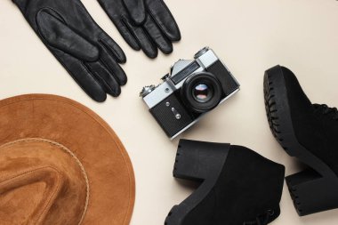 Bej arka planda kadın sonbahar aksesuarları, ayakkabılar ve retro film kamerası. Üst düzey seyahat, tatil konsepti. Düz yatıyordu