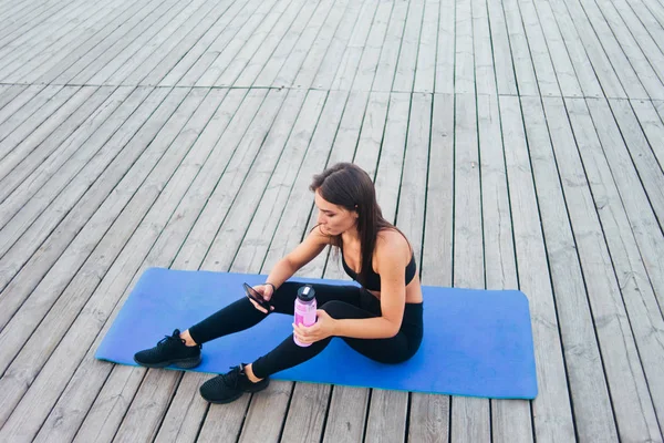 Vrolijke Gezonde Fitness Vrouw Sportkleding Zittend Yoga Mat Chatten Smartphone — Stockfoto