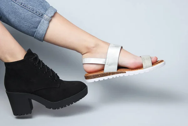 Frauenbeine Jeans Stiefel Und Sandale Sitzen Auf Weißem Hintergrund Kreative — Stockfoto