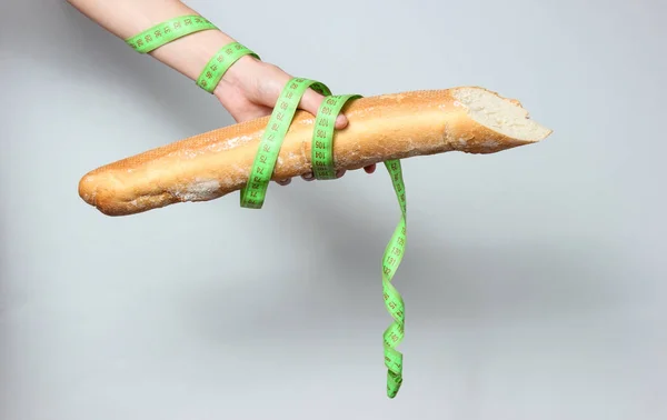 Mujer Envuelta Regla Sostiene Baguette Sobre Fondo Gris — Foto de Stock