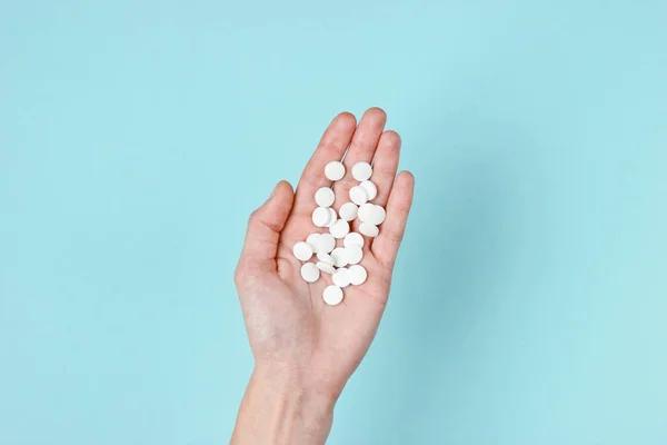 Sok Fehér Tabletta Tenyerében Kék Alapon Orvosi Minimalista Koncepció Felülnézet — Stock Fotó