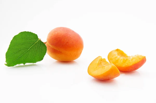 Frutas maduras, jugosas y apetitosas de albaricoque con hojas verdes — Foto de Stock