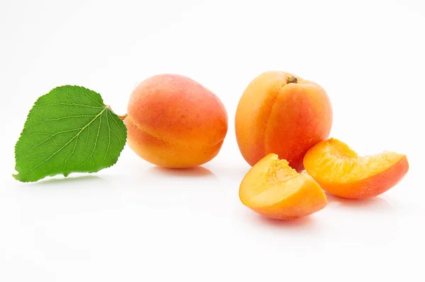 Frutas maduras, jugosas y apetitosas de albaricoque con hojas verdes — Foto de Stock