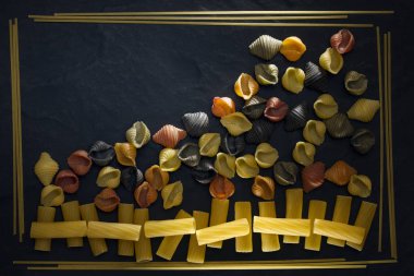 Pişmemiş makarnayı yakından çek. Makarna, vermicelli ve spagetti 'nin soyut bir resmi, siyah arkaplanda farklı bir çerçevede.