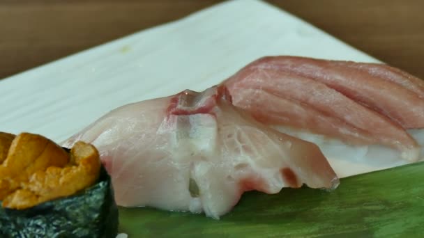 Variety of sushi on green leaf — Stock Video