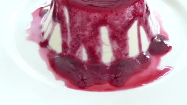 Панна Котта с ягодной саузой в тарелке — стоковое видео