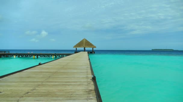 Wooden pier in ocean with placid skies — Stock Video