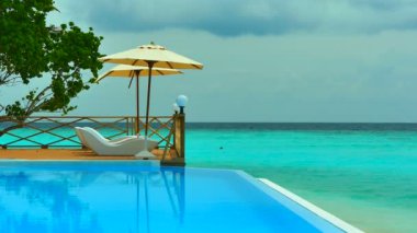 Şezlong ayakta yakınındaki Yüzme Havuzu ile okyanus 