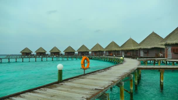 Houten bungalows in oceaan met wolkenluchten — Stockvideo