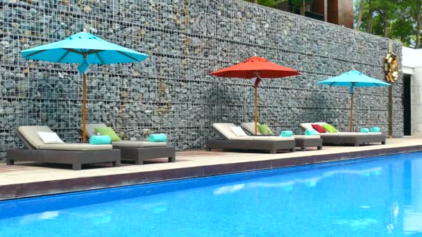 Sunbeds with umbrellas near Swimming pool — Stock Video