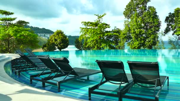 Chaises longues dans la piscine au bord de la mer  